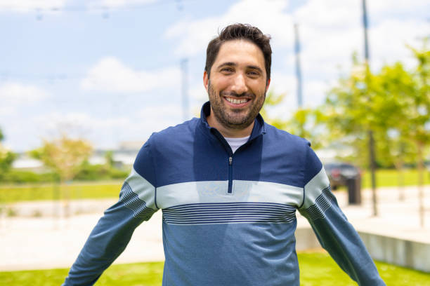 A portrait outdoors with a green park in the background